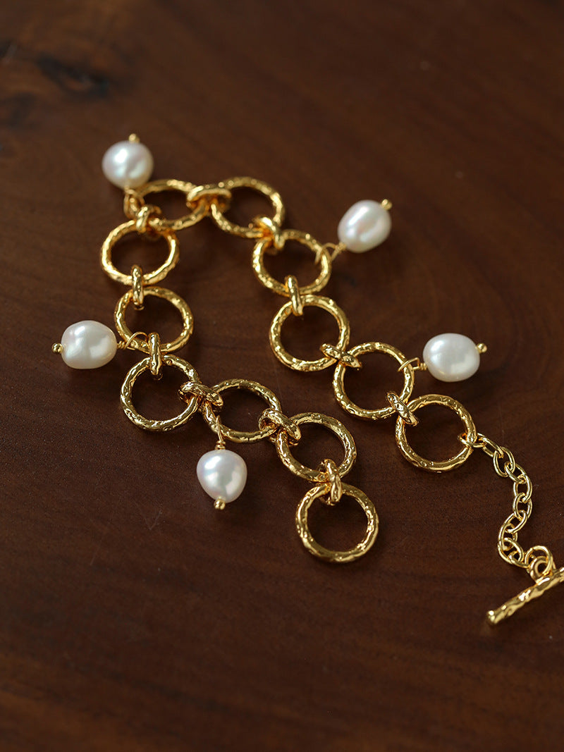 Alternate view of the freshwater pearl charm bracelet and its textured gold-plated links.