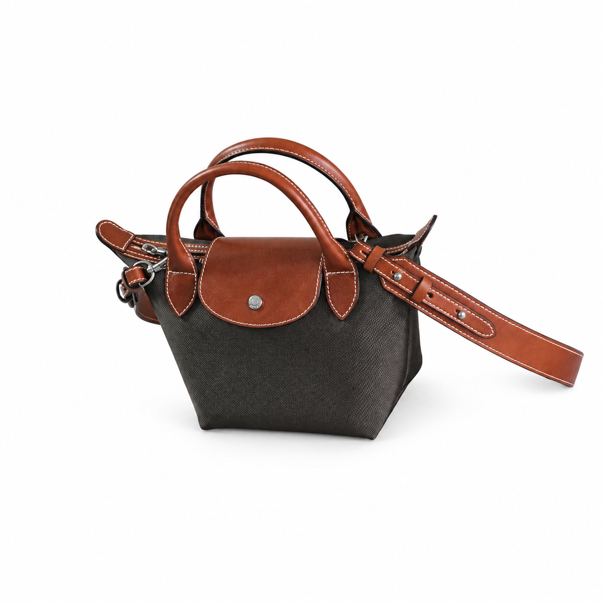 Small dark tote with brown trim, twin handles and an adjustable shoulder strap.