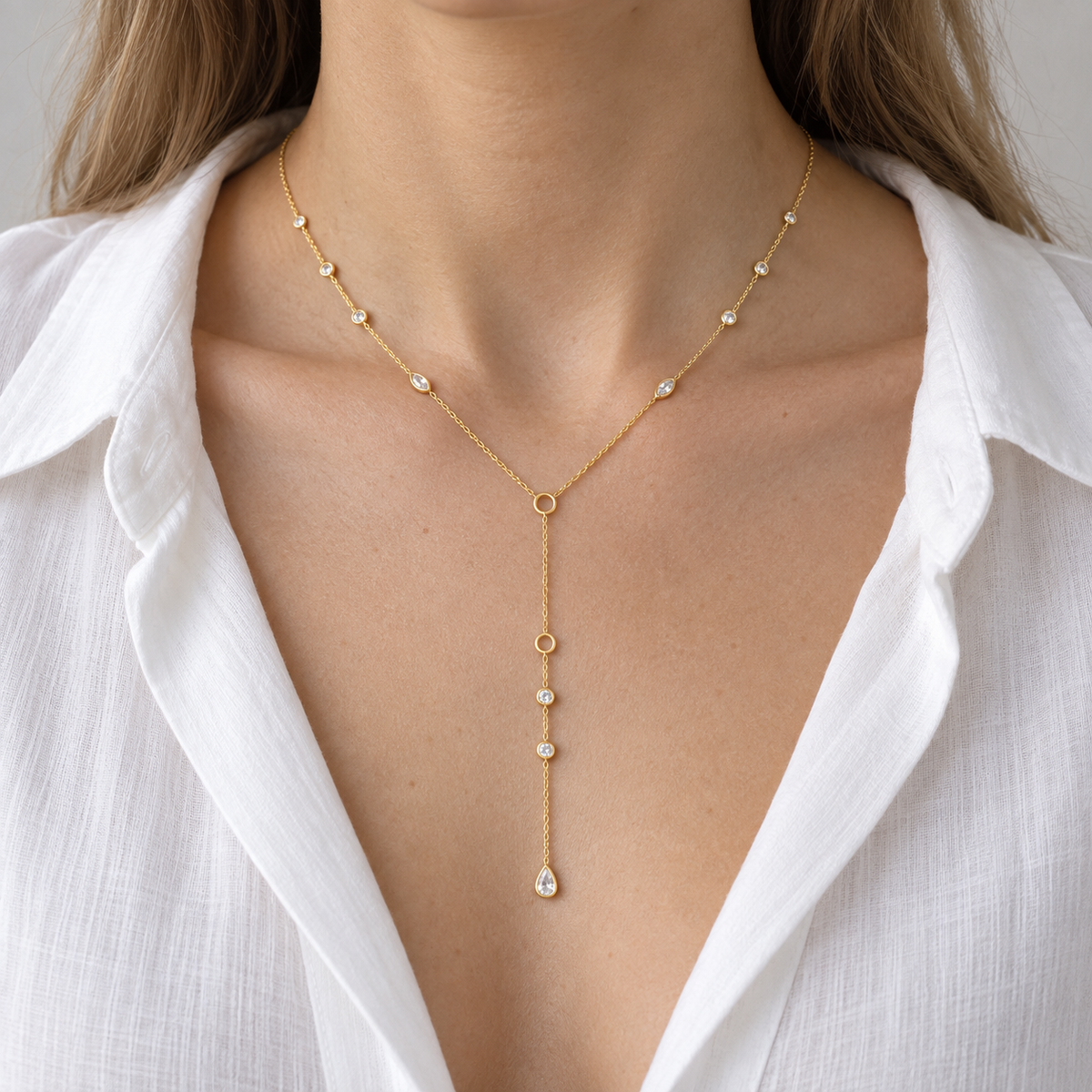 Y Zirconia Accent Necklace worn with an open white shirt, showing the delicate drop and clear stone accents.