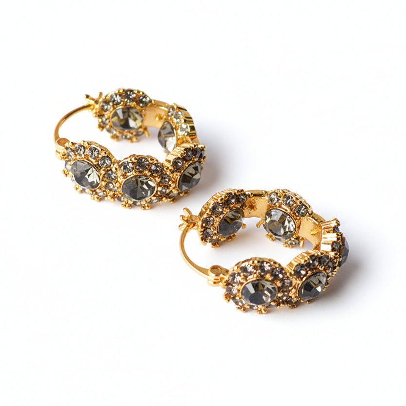 Gold-tone hoop earrings with dark faceted flower-shaped clusters.