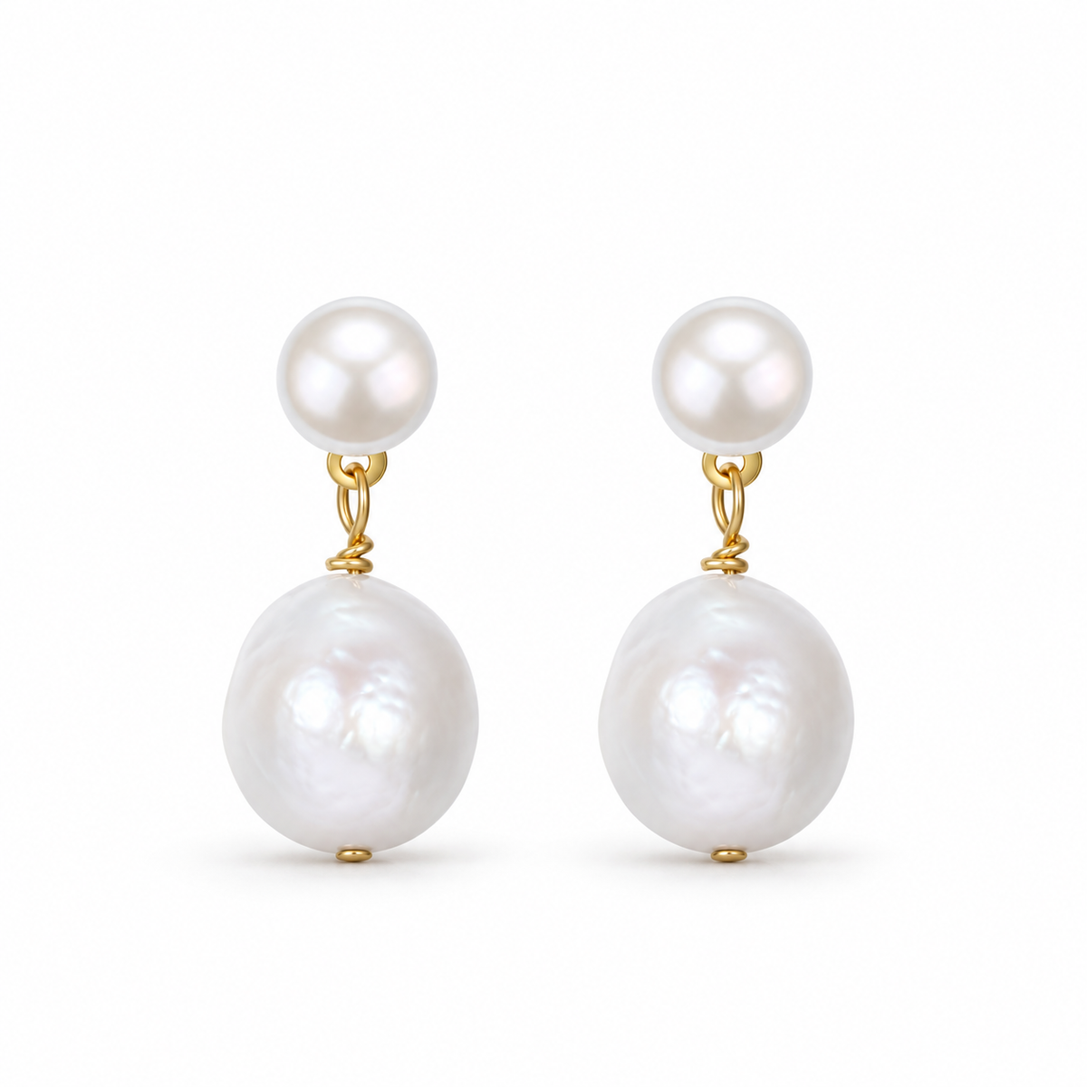 A pair of white pearl drop earrings with gold-tone links and larger irregular pearl drops on white.