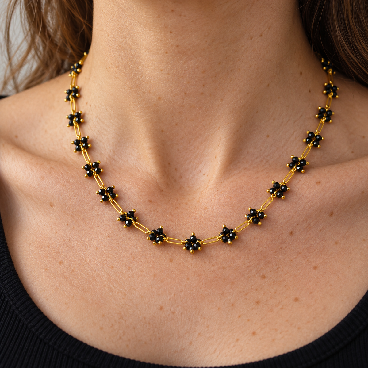 Floral Gold Crystal Necklace worn at the neckline, showing black floral clusters and gold-tone links