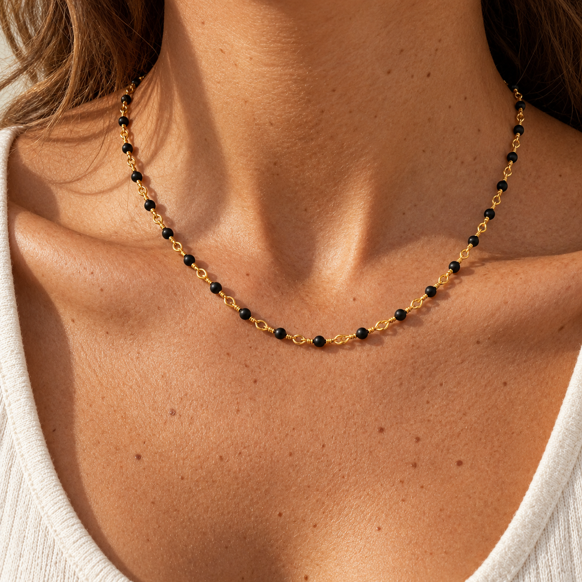 Gold Bead Accent Necklace worn at the neckline, close-up of black beads and gold-tone links